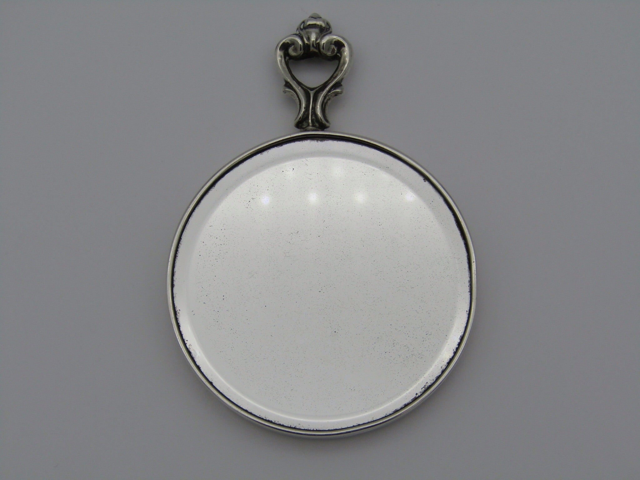 A sterling silver hand mirror by Cartier. Circa 1920s.